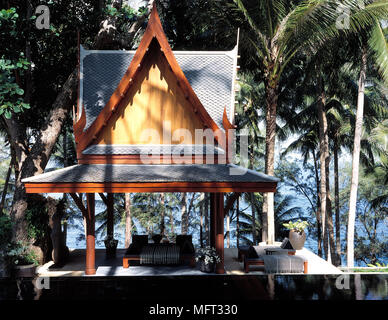 Villa privata o salas nei giardini dell'hotel resort piscina lettini palme; esterni ville tropicale orientale orientale Foto Stock