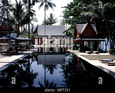 Villa privata o salas nei giardini dell'hotel resort piscina lettini palme; esterni ville piscine tropicali orientale orientale Foto Stock