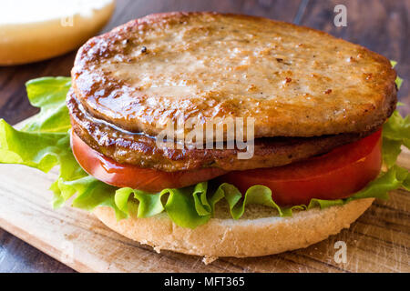 Aprire il doppio Burger con carne di tacchino, lattuga e pomodoro su una superficie di legno. Un Fast Food Concept. Foto Stock