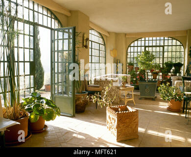 Paese in stile giardino camera con pavimento piastrellato e la luce del sole attraverso Windows, Foto Stock