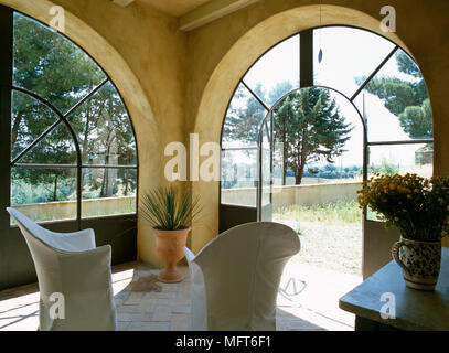 Coppia di sedie sul patio nel giardino camera con portale ad arco Foto Stock