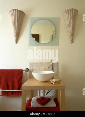 Bagno moderno dettaglio con un lavandino su di un supporto di legno scanalato candelabri a muro e un vetro smerigliato specchio. Foto Stock