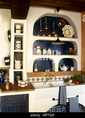 Rustico, country kitchen dettaglio con curvatura scaffalatura di nicchia sopra un lavandino doppio. Foto Stock