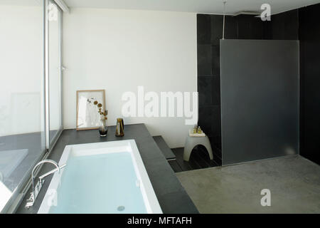 Vasca incassata con surround ardesia in bagno moderno Foto Stock