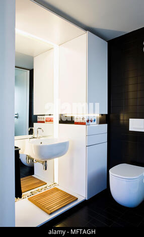 Specchio sopra montato a parete lavandino in bagno moderno privato Foto Stock