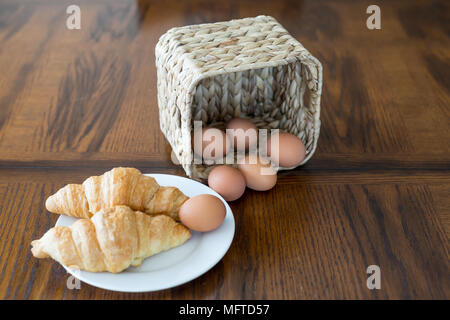 Cornetti e rosolare le uova nel paniere pronto per una sana prima colazione Foto Stock