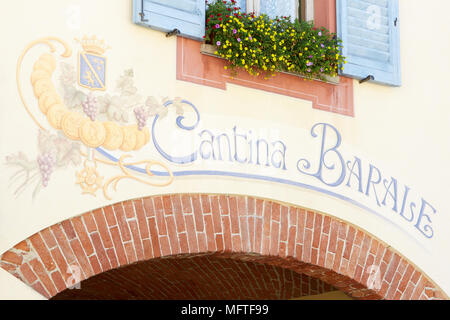 Il logo della cantina Cantina Barale dipinta sulla parete antica con mattoni rossi arco in una soleggiata giornata estiva in Piemonte, Italia Foto Stock