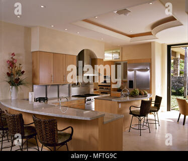 Sgabelli Da Bar a isola centrale bar per la colazione nella cucina  contemporanea con unità di legno Foto stock - Alamy