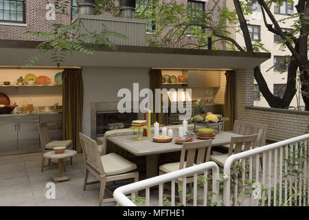 Tavolo e sedie sul patio esterno con riscaldamento e attrezzature da cucina Foto Stock