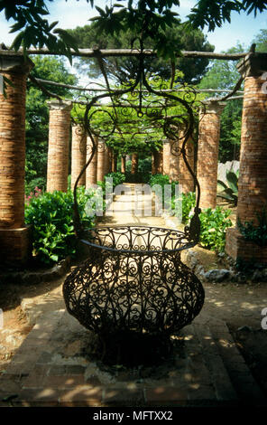 I giardini di Villa Cimbrone con un lastricato sentiero attraverso pilastri in mattoni, e decorativi, ferro battuto bene, Ravello, Italia. Foto Stock