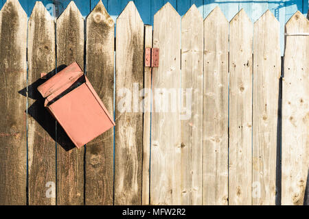 Vecchia staccionata in legno e un storto arrugginito letter box Foto Stock