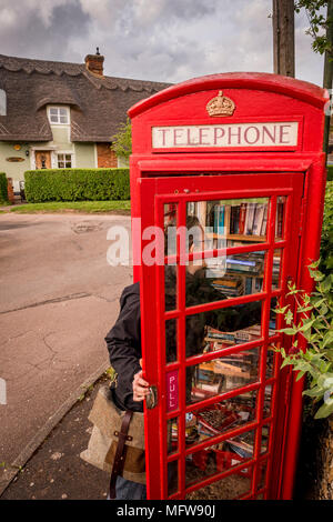 Hinxton, Cambridgeshire. Una cabina telefonica è ridefinito come una biblioteca. Foto Stock