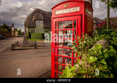 Hinxton, Cambridgeshire. Una cabina telefonica è ridefinito come una biblioteca. Foto Stock