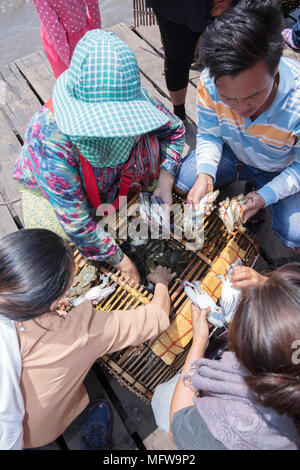 Cham donne gamberi di prendere granchi al di fuori di un tradizionale bambù cambogiano crab trappola a Kep mercato in Kampot provincia Foto Stock