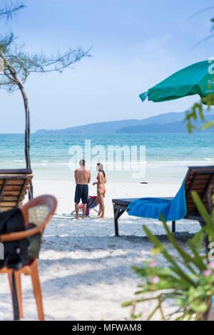 Candide colpo di una giovane coppia di parlare su una spiaggia di sabbia bianca su di un isola nel sud-est asiatico Foto Stock