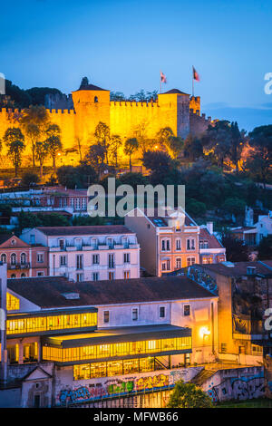 Lisbona portogallo città, vista del Castelo de Sao Jorge illuminata di notte con le affollate hillside edifici del quartiere Mouraria situati al di sotto. Foto Stock