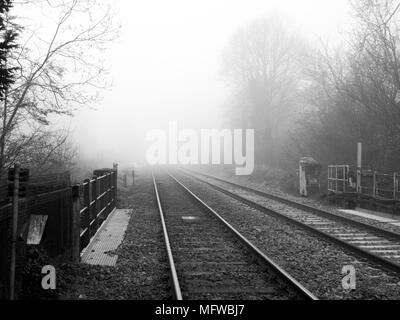 Wessex linea principale di binari ferroviari a West Dean stazione Southampton a Salisbury attraverso Romsey, presa sui primi nebbiosa mattina di primavera Foto Stock