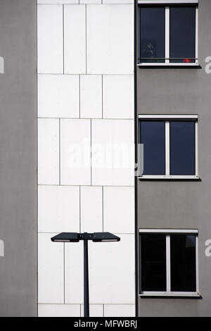 Una lanterna sorge di fronte a una casa moderna facciata con il grigio e il bianco di rivestimento a parete. Foto Stock