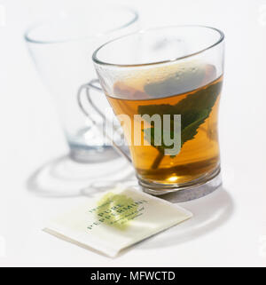 Bicchiere di tè alla menta con foglie Foto Stock