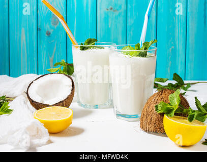 Noce di cocco latte vegano coctail in vetro su sfondo di legno. Foto Stock