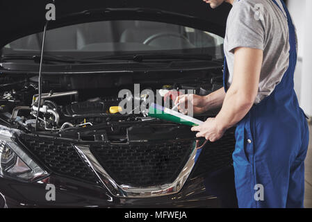 Ritratto di un meccanico al lavoro nel suo garage - Servizio auto, riparazione, manutenzione e concetto di persone Foto Stock