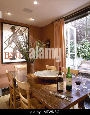 Il numero di bottiglie di vino e i bicchieri sul tavolo di legno in terracotta sala da pranzo Foto Stock