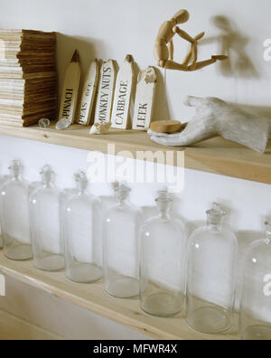 Close up di bottiglie di vetro sul ripiano sottostante ornamenti Foto Stock