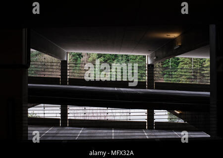 Garage interno con ombre e punti di luce creando una misteriosa sensazione ominus. Foto Stock