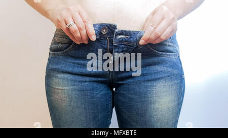 Primo piano della giovane donna con ventre indossano jeans Foto Stock