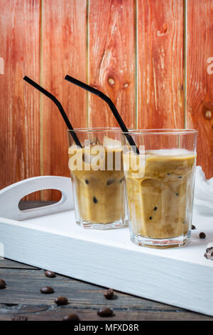 Caffè ghiacciato in vetro su uno sfondo di legno. Foto Stock