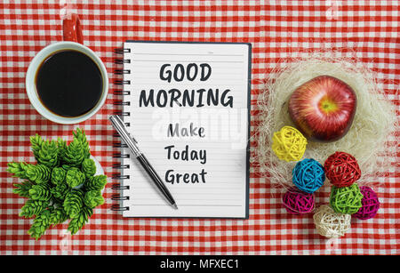 Buona mattina. Fare oggi grande. Notebook con preventivo motivazionale sul tovagliolo rosso con penna tazza da caffè, pianta in vaso e Apple. Foto Stock