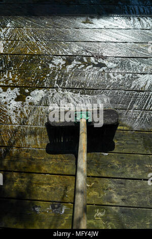 Verde e sporchi coperti di alghe giardino decking in procinto di essere puliti con detergente chimico. Foto Stock