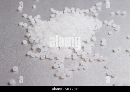 Polipropilene granuli trasparenti su sfondo grigio. Foto Stock