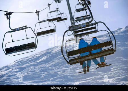 Due gli sciatori seduti su una sedia lift francesi nella località alpina di Courchevel. Foto Stock