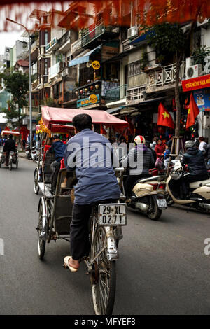 Il cyclo (tre ruote taxi bicicletta) driver nel traffico, Quartiere Vecchio, aka il 36 strade, Hanoi, Vietnam Foto Stock