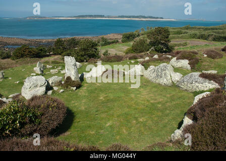 Vista di Halangy giù Village, St Marys, un ferro da stiro insediamento dell'età. In fondo è di un blu limpido del mare e del cielo con Sansone isola in distanza. Foto Stock