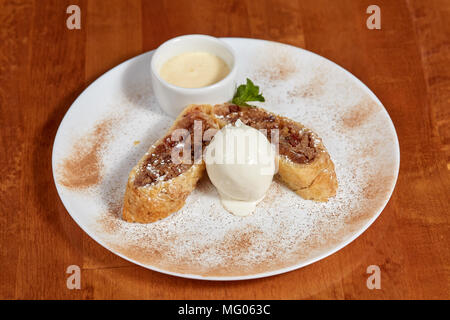 Strudel di mele con gelato scoop su piastra, primo piano Foto Stock