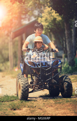 Padre e figlia a cavallo su quad atv sul campo di sporco Foto Stock