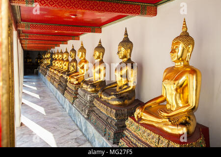 Fila di golden statue di Buddha a Wat Pho noto anche come il Tempio del Buddha Reclinato a Bangkok, in Thailandia. Foto Stock