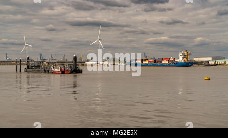 Gravesend, Kent, Regno Unito - 23 Settembre 2017: vista sul fiume Tamigi con turbine eoliche, una nave da carico e il porto di gru in background Foto Stock