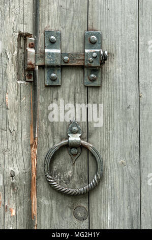 Vintage valvole a saracinesca e vecchi cancelli in legno rotonde con maniglie di metallo in forma di anelli. Foto Stock