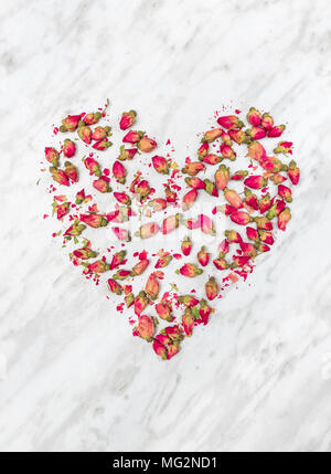 Cuore di rosa appassita fiori, sul grigio chiaro sfondo marmo. Foto Stock