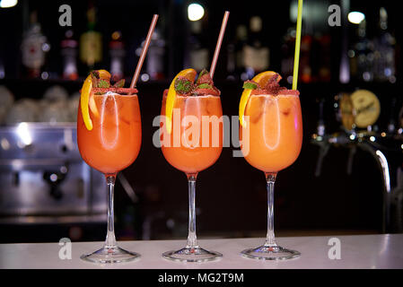 Tre orange cocktail freddi decorate con zucchero briciole, una fettina di arancio e menta sulla barra nel ristorante Foto Stock