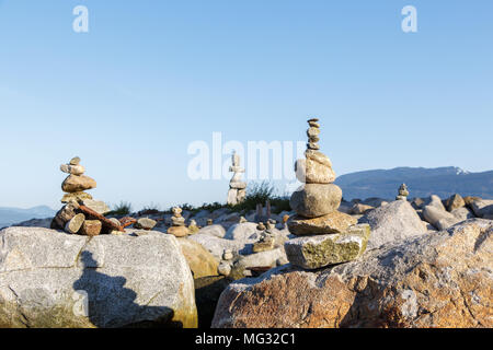 Uomo-realizzato inukshuks con Vancouver inukshuk gigante in background Foto Stock