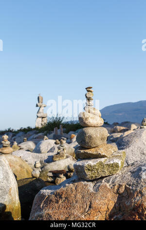 Uomo-realizzato inukshuks con Vancouver inukshuk gigante in background Foto Stock