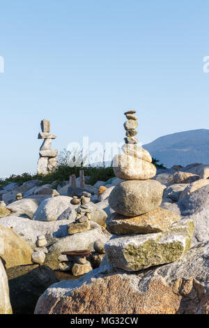 Uomo-realizzato inukshuks con Vancouver inukshuk gigante in background Foto Stock