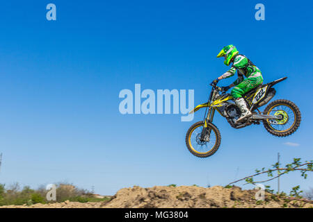 Motociclista vola nella molla blu cielo Foto Stock