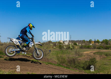 Motociclista vola nella molla blu cielo Foto Stock