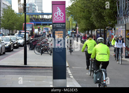 Le donne i ciclisti ride passato il superhighway di contatore di bicicletta come loro capo sud lungo la CS6 bike lane su Blackfrairs Road nel centro di Londra durante il Foto Stock