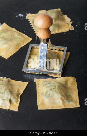 Fare Ravioli di spinaci su nero ardesia Foto Stock